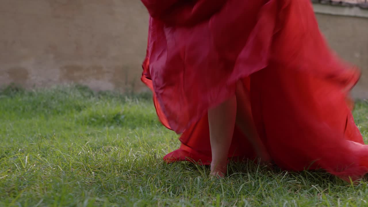 Woman in Red skirt walking in grass bare feet slowly