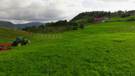 beautiful rural scene of tractor moving field, silage production from grass in norway