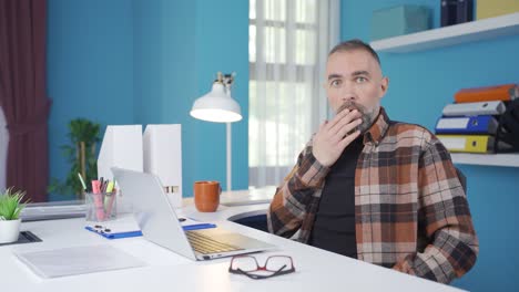 Freelance-businessman-surprised-by-what-he-sees-on-laptop.