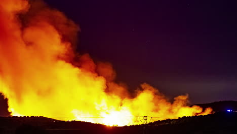 incendio forestal muy grande con llamas elevadas cerca de una línea eléctrica