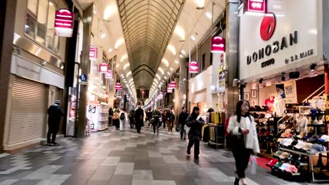 people walking through a bustling shopping arcade