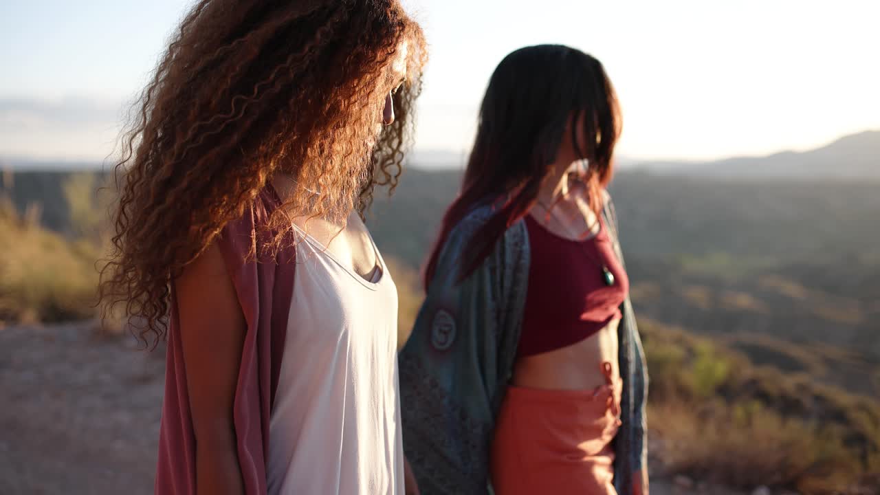 Two women friends walking outdoors during golden hour