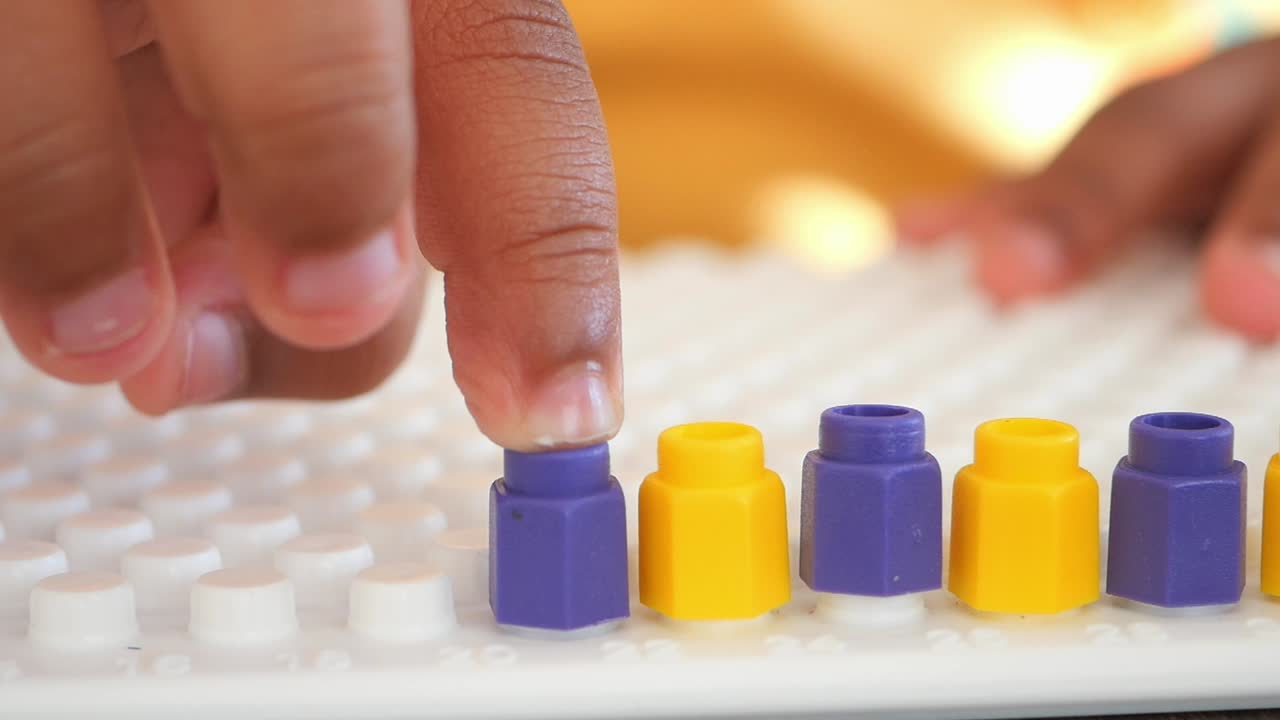 niño jugando con clavijas coloridas en una tabla de clavijas