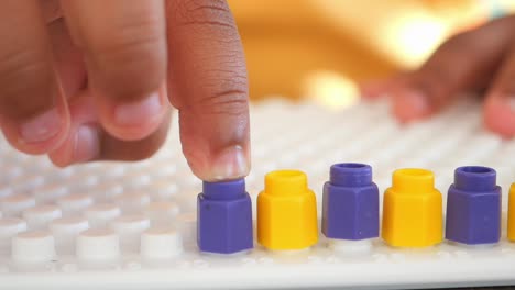 child playing with colorful pegs on a peg board