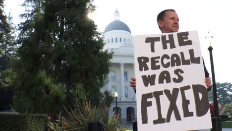 male political protester with the recall was fixed sign