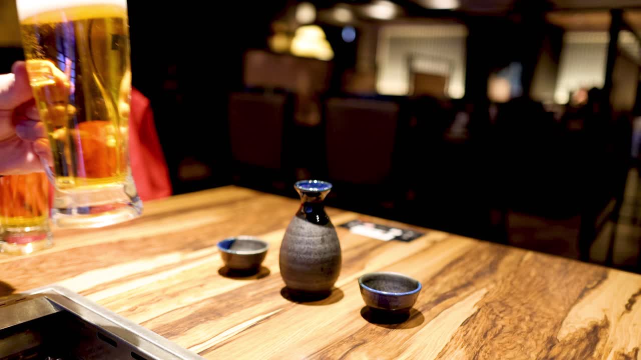 두 사람이 맥주 한 잔을 주고받고 있다.