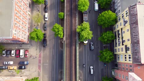 Die-Kamera-Verfolgt-Autos-Und-Straßenbahnen-Und-Endet-Mit-Einem-Panorama-Des-Fernsehturms.-Großartige-Luftaufnahme.-Flug-Nach-Oben-Kippbare-Drohnenaufnahmen-Von-Berlin,-Prenzlauer-Berg,-Schönauer-Allee,-Frühjahr-2022,-Film-Von-Philipp-Marnitz