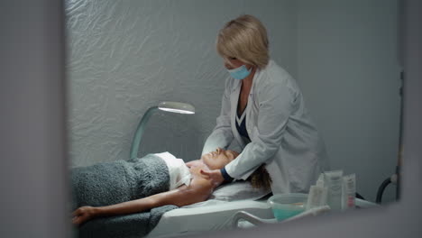 médico de belleza masajeando el cuello después del tratamiento de nutrición. esteticista tratar la piel