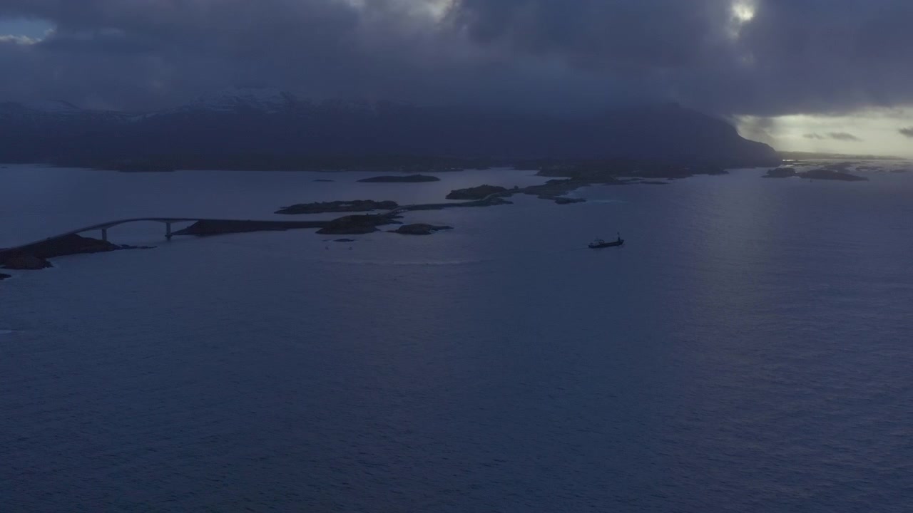 Ampia ripresa aerea di una nave mercantile che attraversa la Strada dell'Atlantico, situata nella contea di Møre og Romsdal, in Norvegia. Si tratta di un tratto di 8,3 chilometri della strada provinciale 64