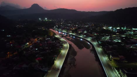 aerial descendig view at night over the parrot river in santo antonio city at ilha do principe (prince island) africa