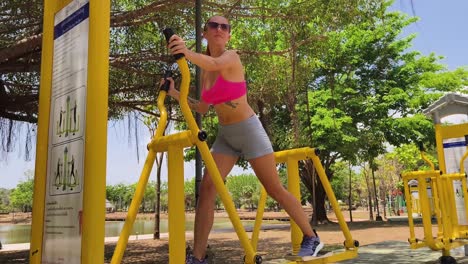 woman exercising on outdoor exercise equipment in a park