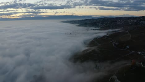 Overflying-fog-retreating-down-Lavaux-landscape-towards-Lake-LÃ©man-at-dusk---Switzerland