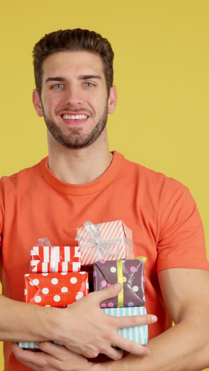Happy man holding a stack of colorful gifts
