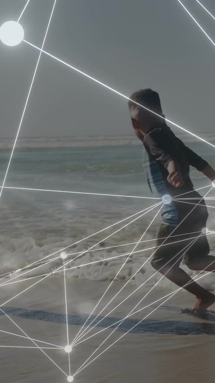 Vertikal video: Dreng skifter position på boardet, stiger derefter af, leger langs kysten med teknologisk HUD-sporing