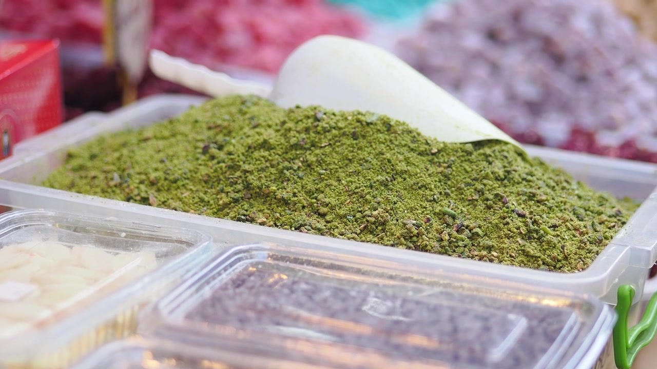 Ground Pistachios in a Plastic Container at a Market