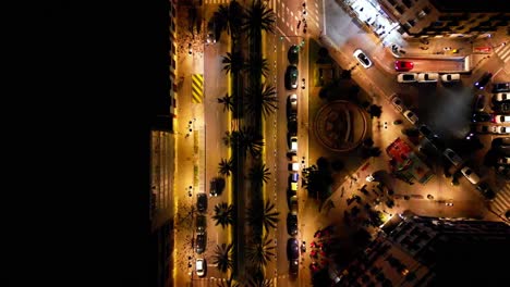 birds eye close up shot of a main street at night in downtown valencia , slow moving shot , with people and cars