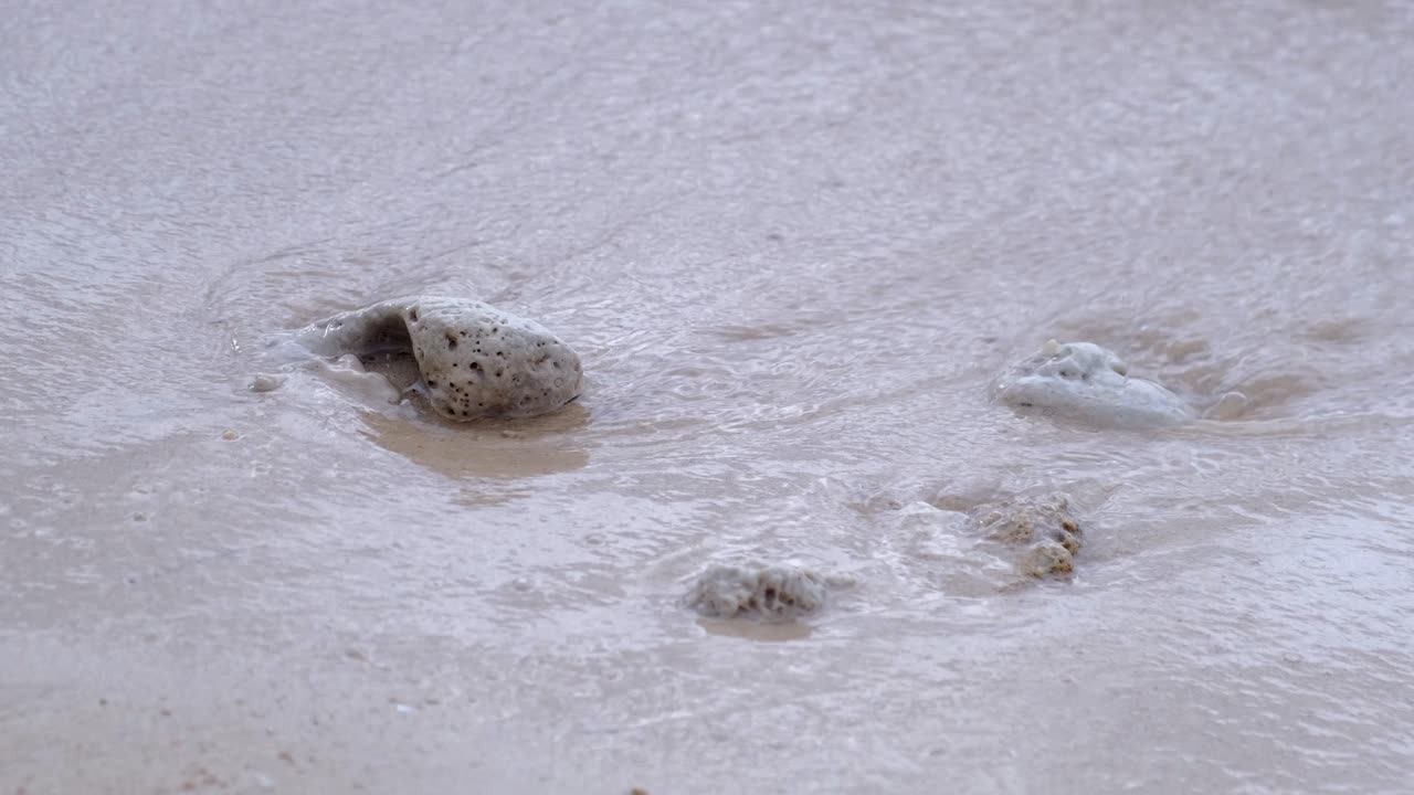 바다 파도가 튀는 모래에 노파 돌