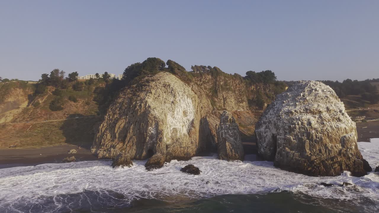 Cinematic tracking along the steep sea cliffs and sea stacks of Constitucion. Lush vegetation meets the ocean spray