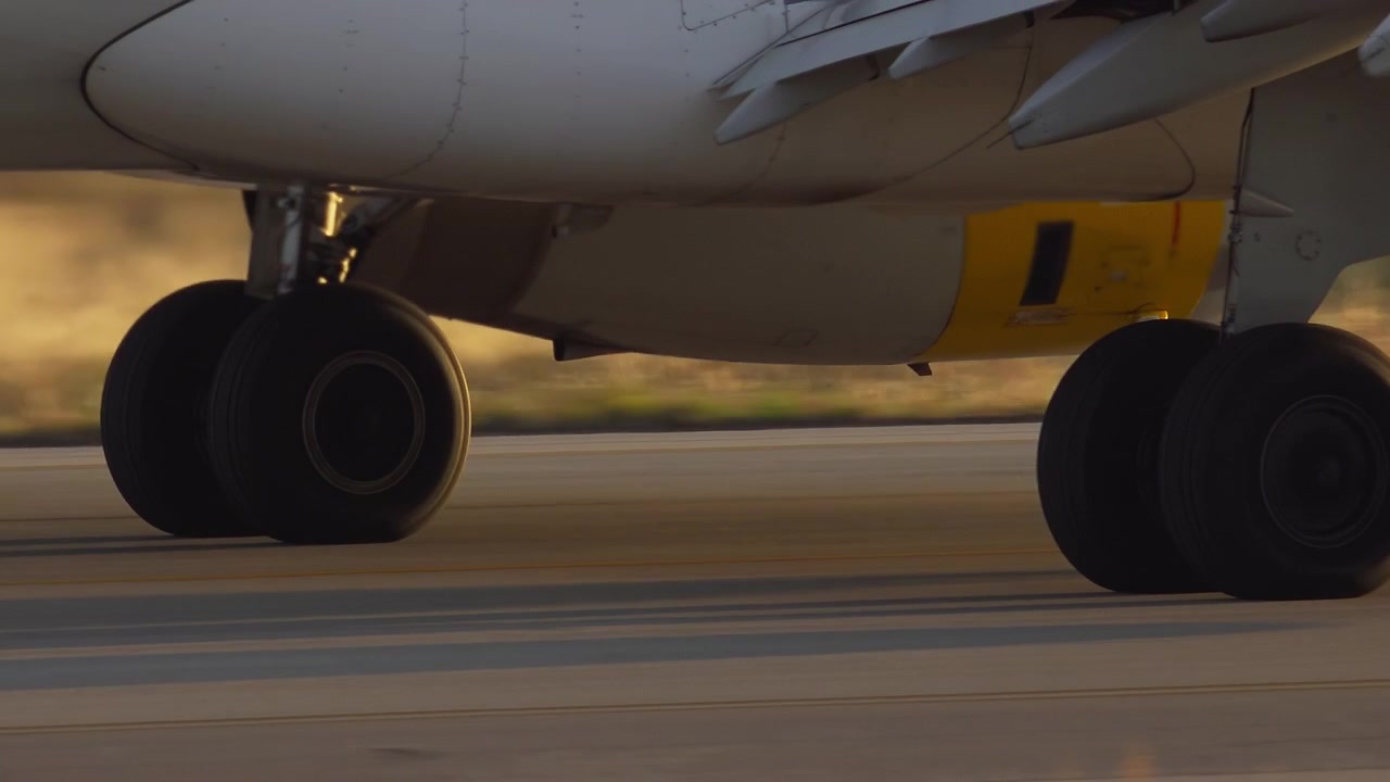 Carrello di atterraggio di un aereo in movimento sulla pista all'ora d'oro