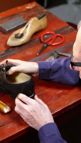 shoemaker examining a shoe