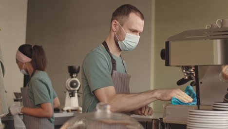 two baristas cleaning workplace