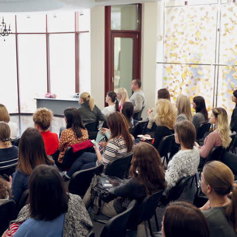 many adults sitting in a modern auditory. speaker man discussing about marketing and management strategy on the stage of a hall. seminar concept.