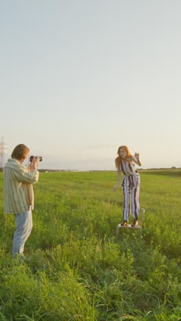 photographer capturing a model in a field at sunset