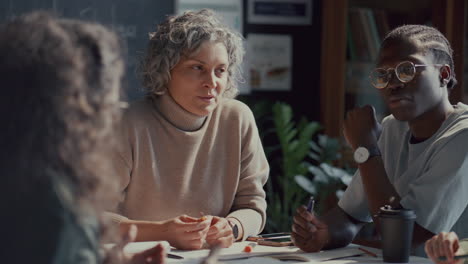 teacher answering questions of students during lesson in language school