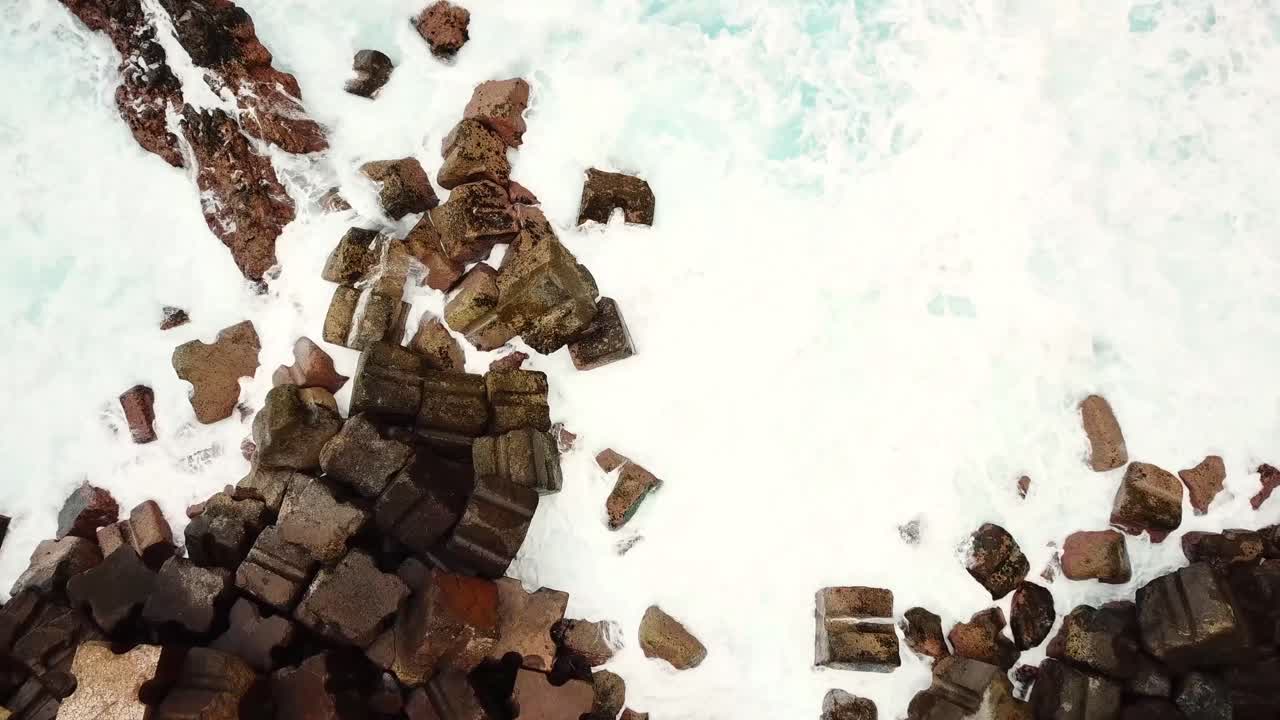 Majestic coastal cliffs of Seixal, Madeira, rising from the ocean, adorned with lush greenery, cascading waterfalls, and terraced hillsides under a misty atmosphere