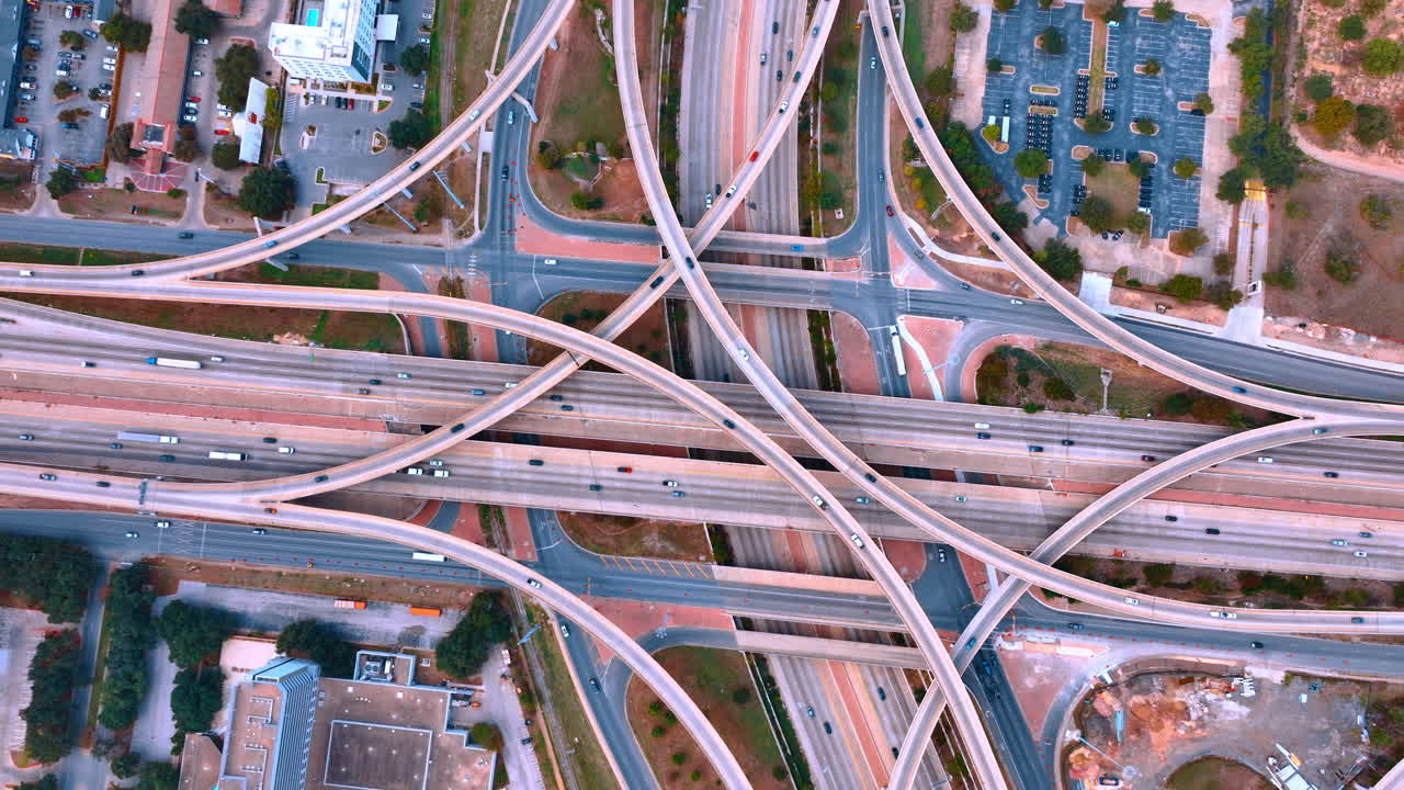 Lots of intertwining roads and trestles with fast moving cars. Modern interchange in the big city. Top view