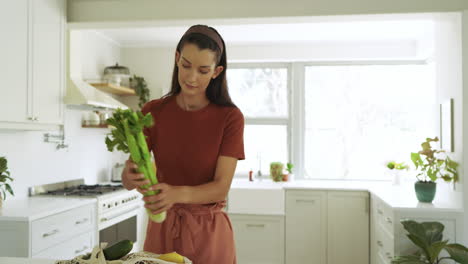 smiling woman in kitchen preparing meal, enjoying cooking at home