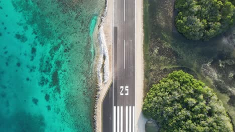 gran roque airstrip in los roques with turquoise sea and lush greenery, aerial view