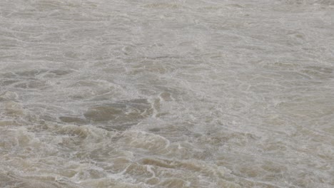 looking down at the raging water of the ottawa river from the lookout bridge and panning up to reveal the hydro electric dam on chaudière island as the flood waters rage through the levee