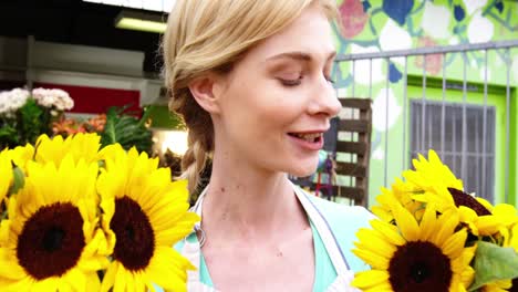 Schöne-Floristin,-Die-Einen-Strauß-Sonnenblumen-Riecht