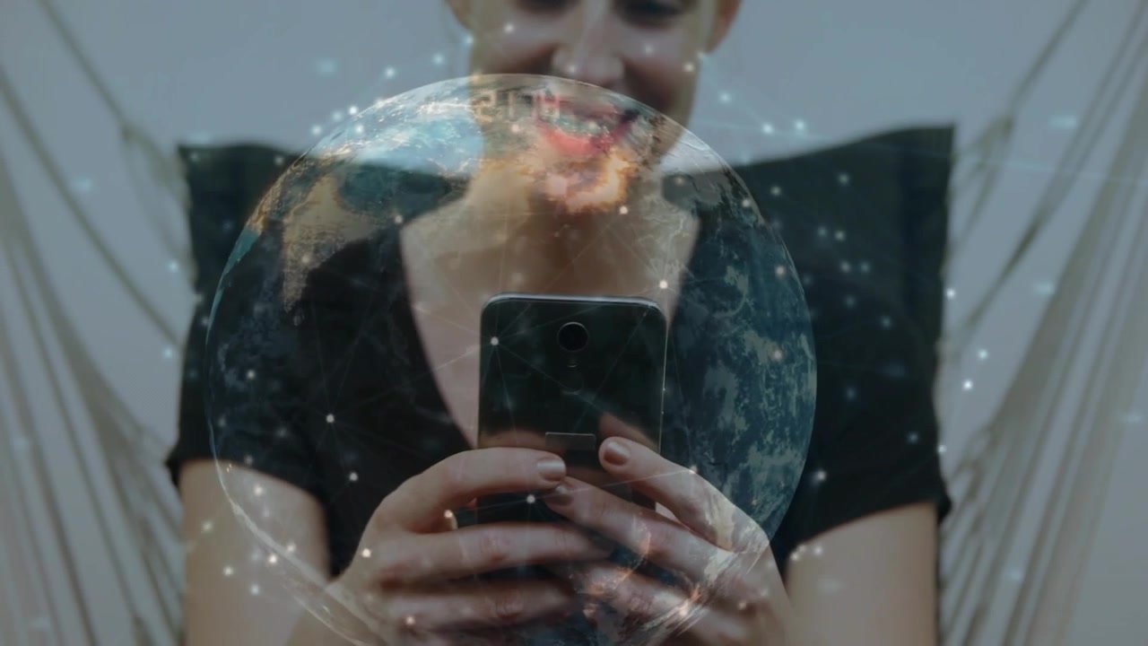 Video verticale: Donna seduta con un telefono in mano, con un top nero, che sorride mentre una sovrapposizione di un globo appare a casa