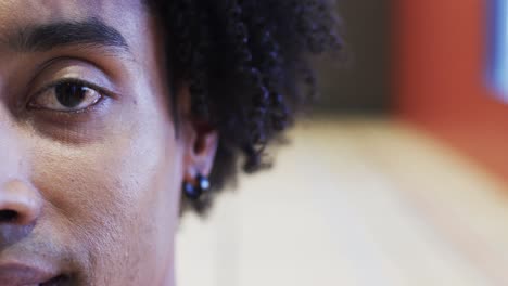 half portrait of male african american basketball player in indoor court, in slow motion