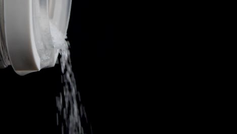 Close-up-shot-of-pouring-out-sugar-out-of-a-transparent-container-in-slow-motion