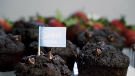 nice shot of chocolate covered strawberries and beet infused muffins spinning on a lazy susan with the background out of focus