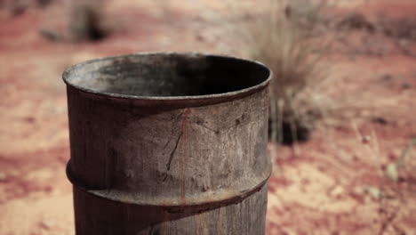 old-empty-rusted-barrel-on-sand