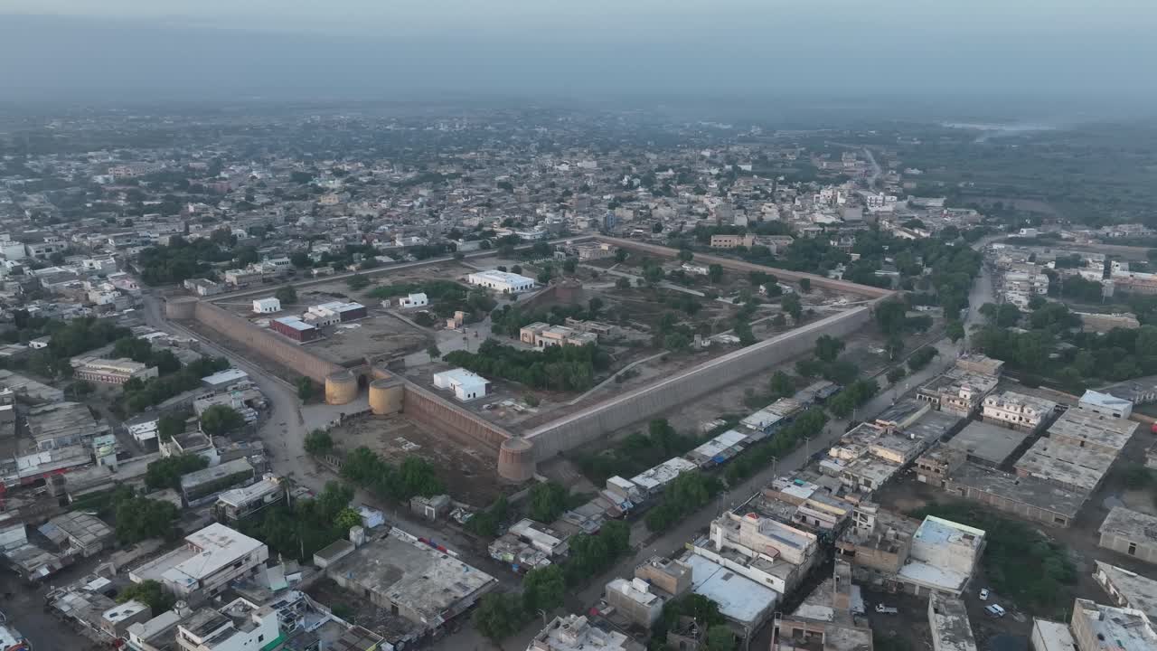 Ripresa aerea con drone rotante sopra case residenziali nella città di Umerkot, Tharparkar, Pakistan, durante la sera.