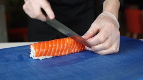 el chef está preparando un rollo de sushi de salmón.