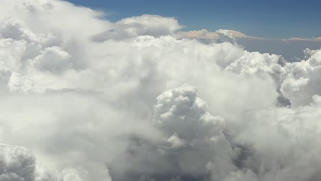 an immersive pilot’s pov view of theatening massive cumulonimbus storm clouds from a jet cockpit, while flying at very high altitude cruise level