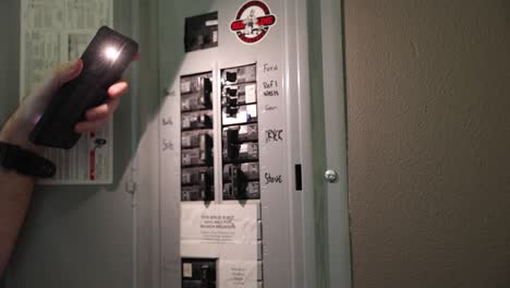 man flips power switches during a power outage