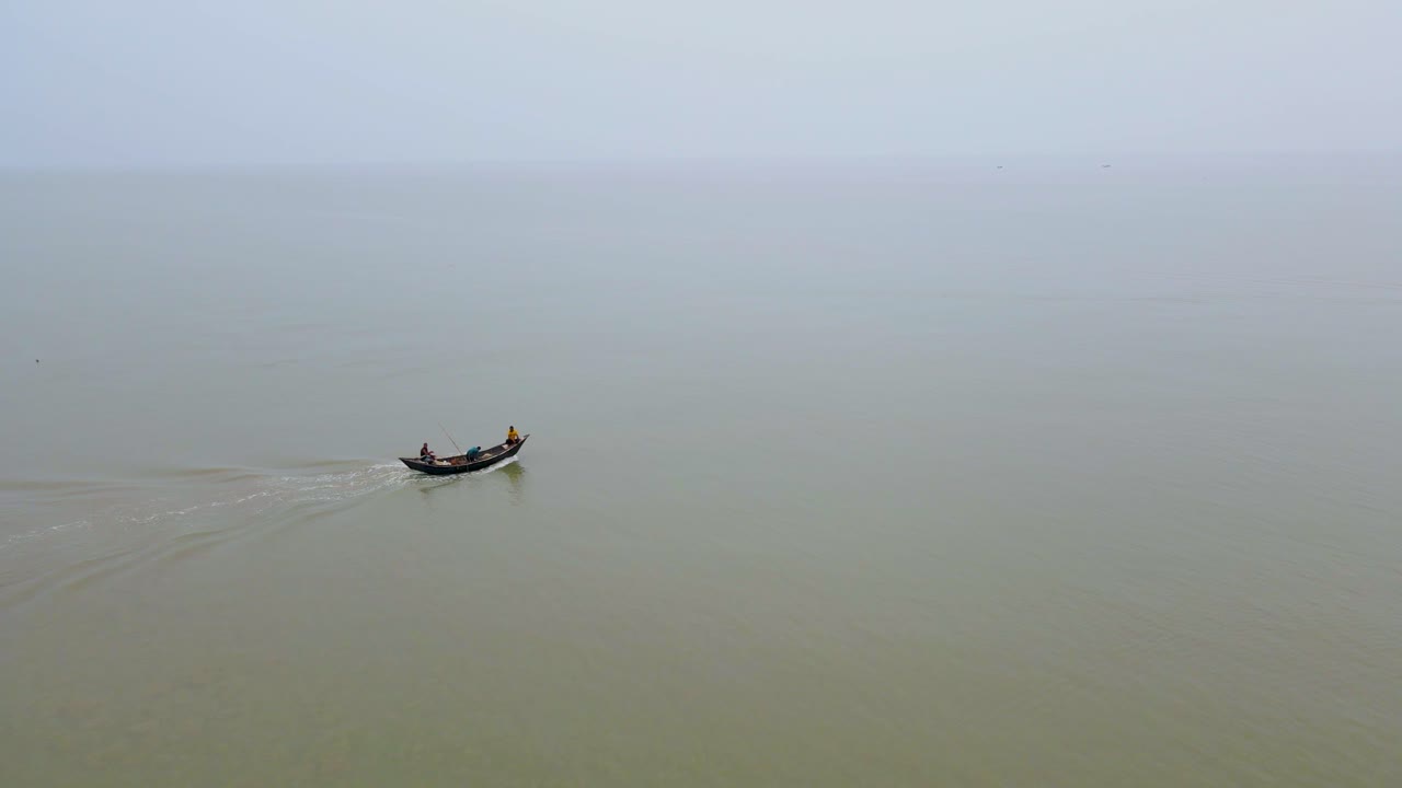 Dois homens navegam em um barco de pesca de arrasto para o Oceano Índico, pescando na Baía de Bengala, Bangladesh.