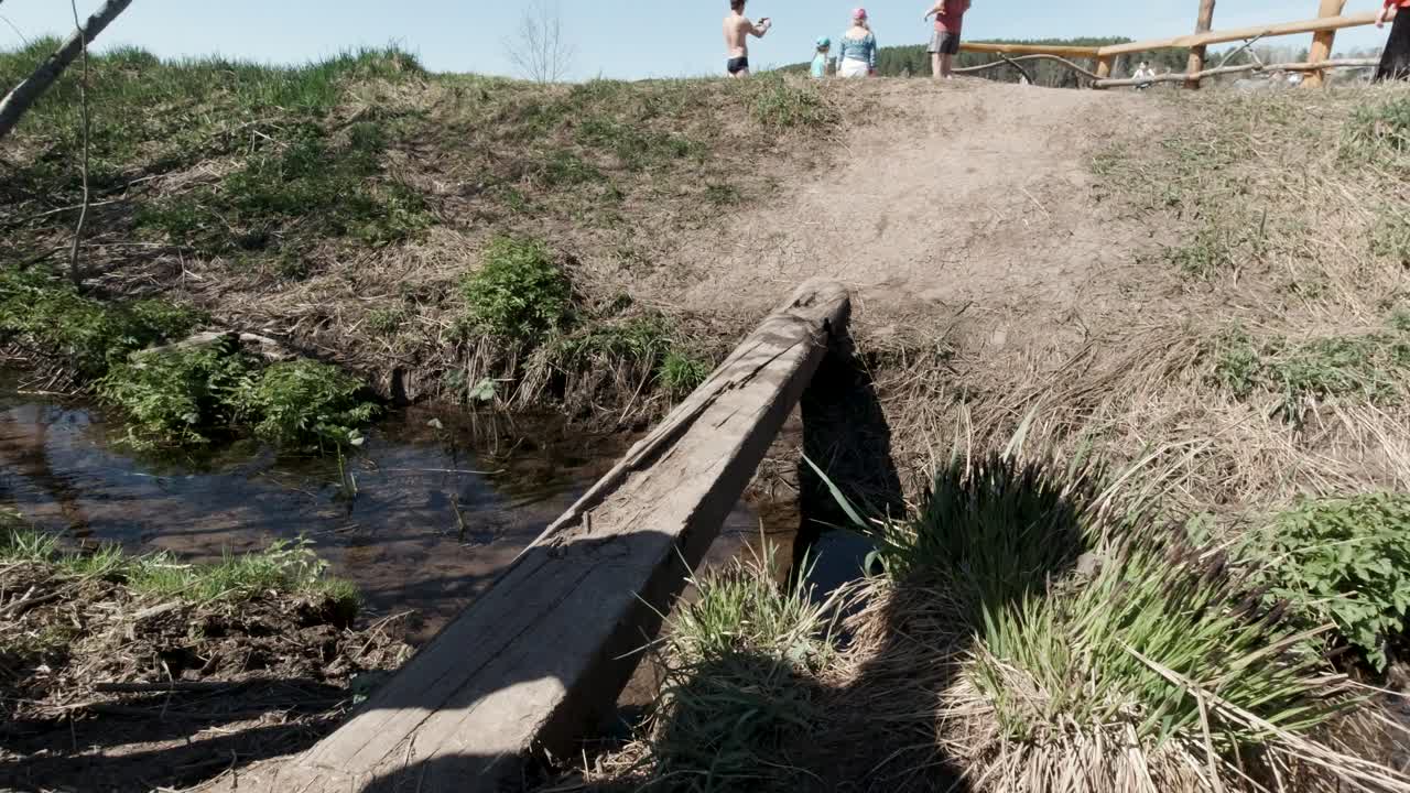 niños caminando a través de un puente de madera en el parque