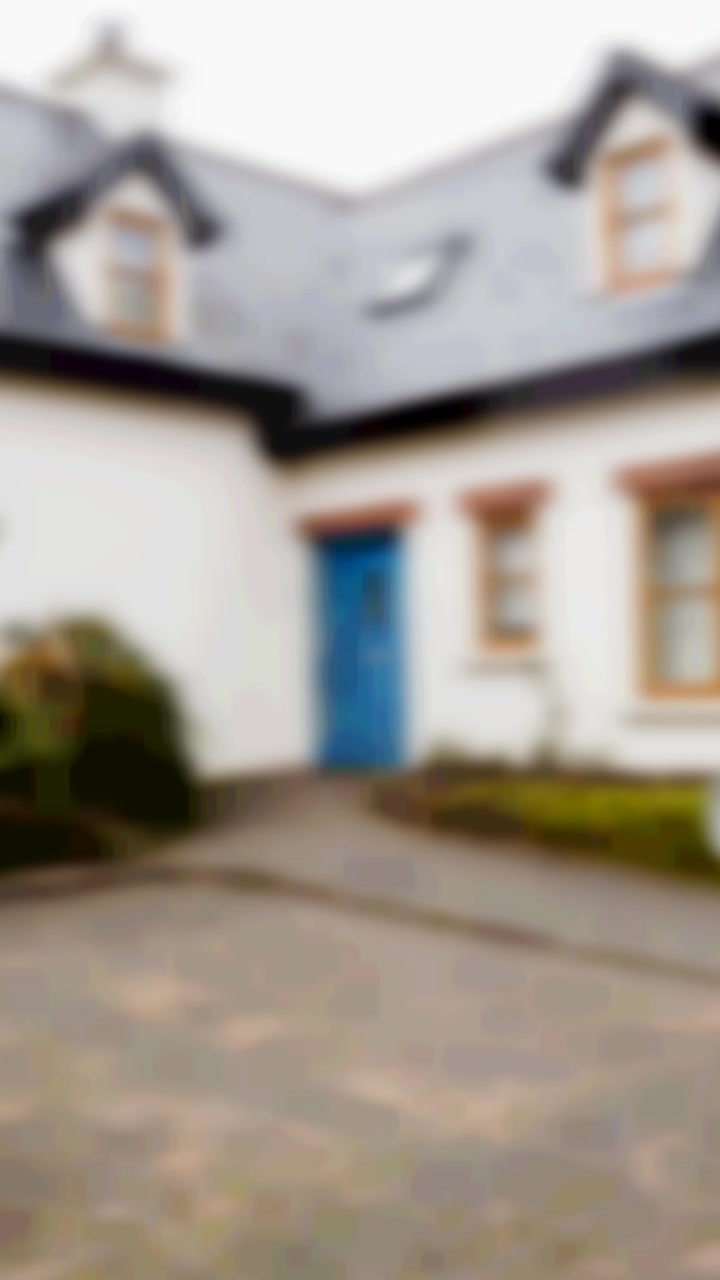 Animation af sølv nøglering med husnøgle, hængende foran et sløret hus med et til salg-skilt.