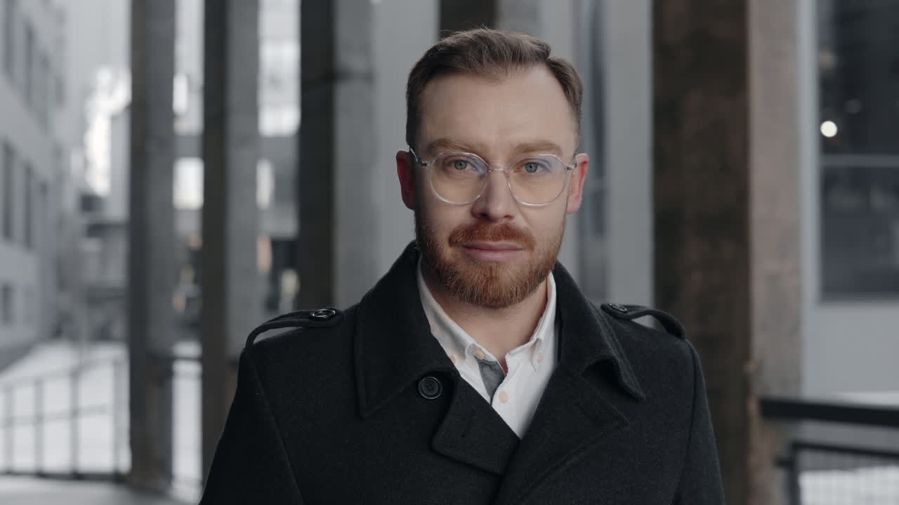 Portrait of a man with glasses and beard wearing a coat