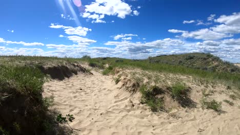 a trail made of sand going off into the distance in the country on a cloudy sunny day