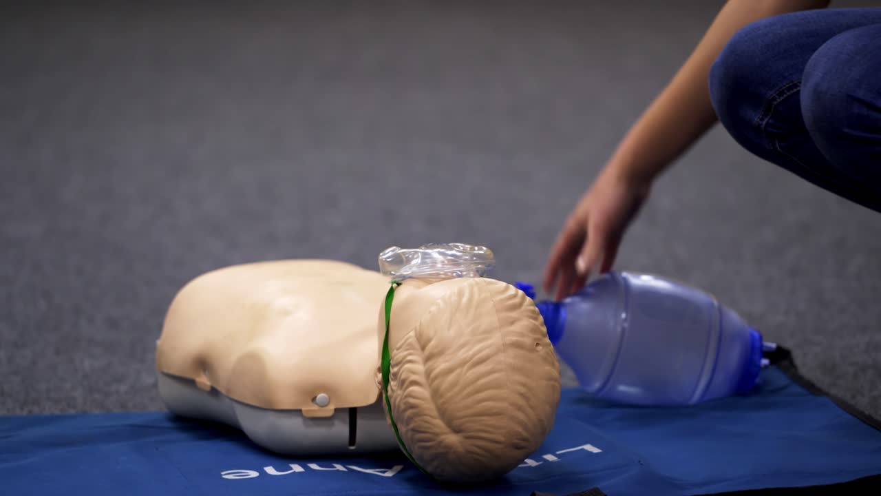 Teaching cardiopulmonary resuscitation with dummy. Instructor demonstrating CPR on mannequin at first aid training course