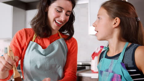 Girl-and-mother-glazing-dough-for-challah-bread,-close-up